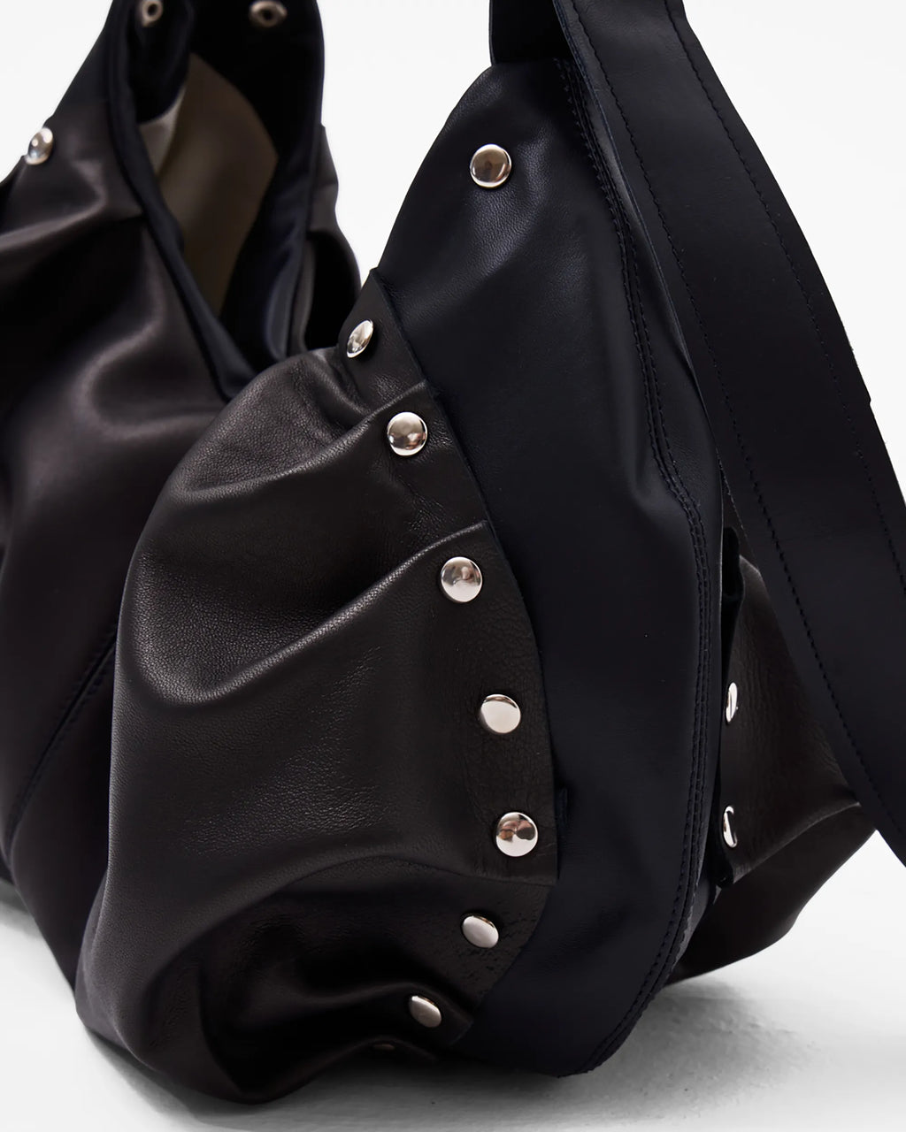 details of black leather shoulder bag with bespoke buckle and ruching