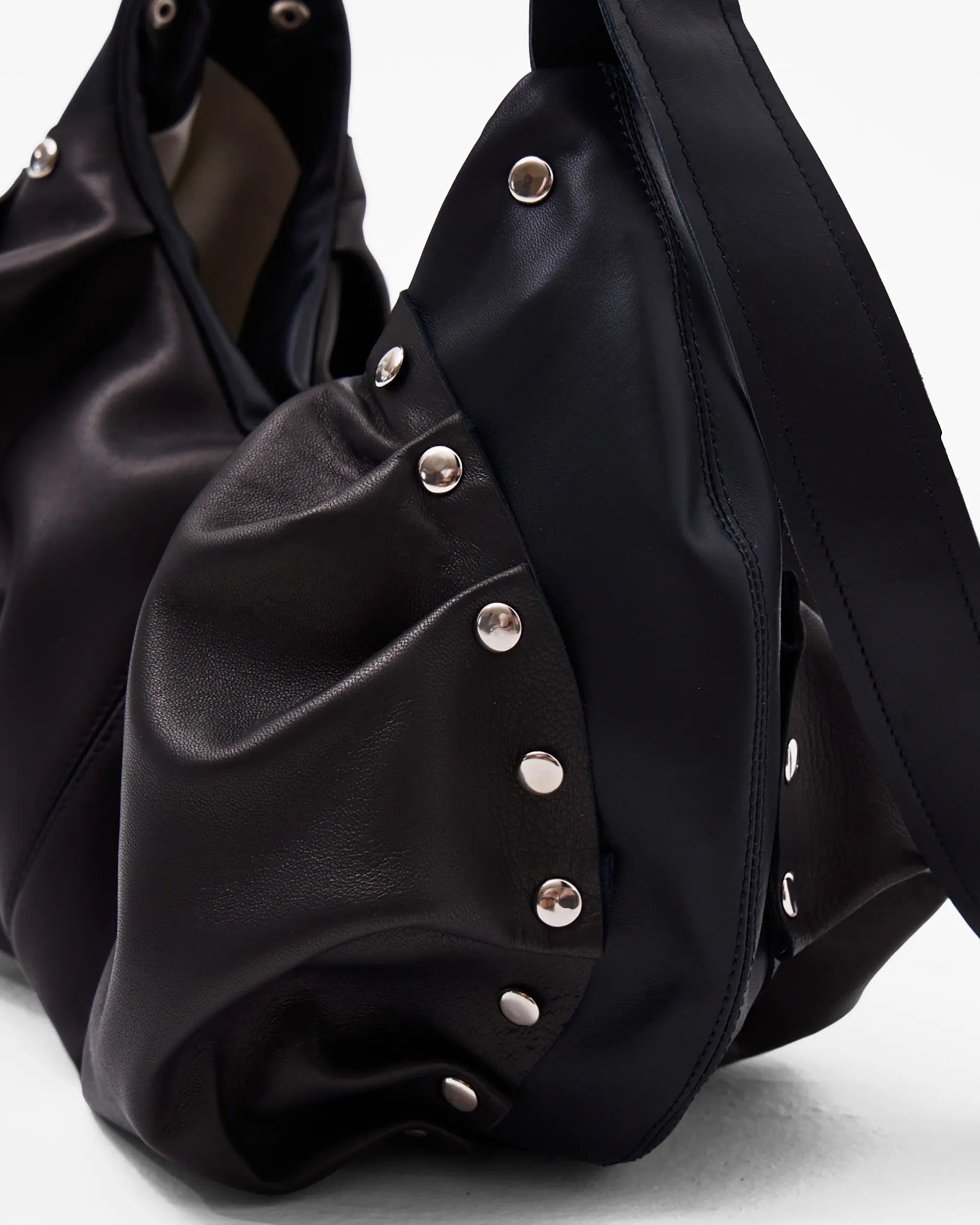 details of black leather shoulder bag with bespoke buckle and ruching